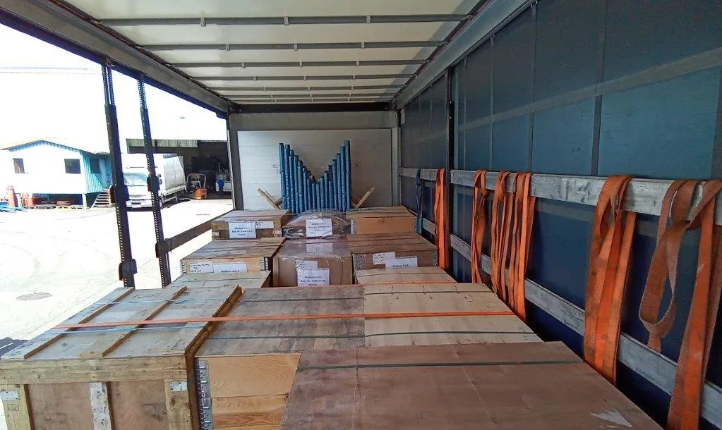 Caisses en bois arrimées par sangles sur un camion